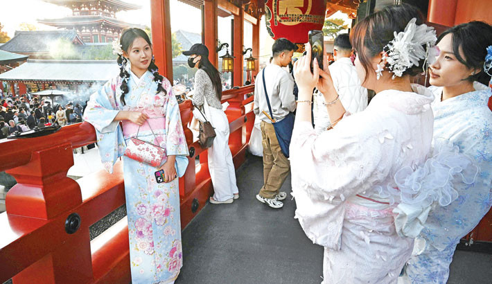 Chinese tourists wear kimonos as they visit the Sensoji Temple in the Asakusa district of Tokyo on 15 November 2025. China has advised its citizens to avoid travelling to Japan, following a diplomatic feud sparked by remarks from Tokyo's new premier about a hypothetical attack on Taiwan. 	PHOTO:  AFP